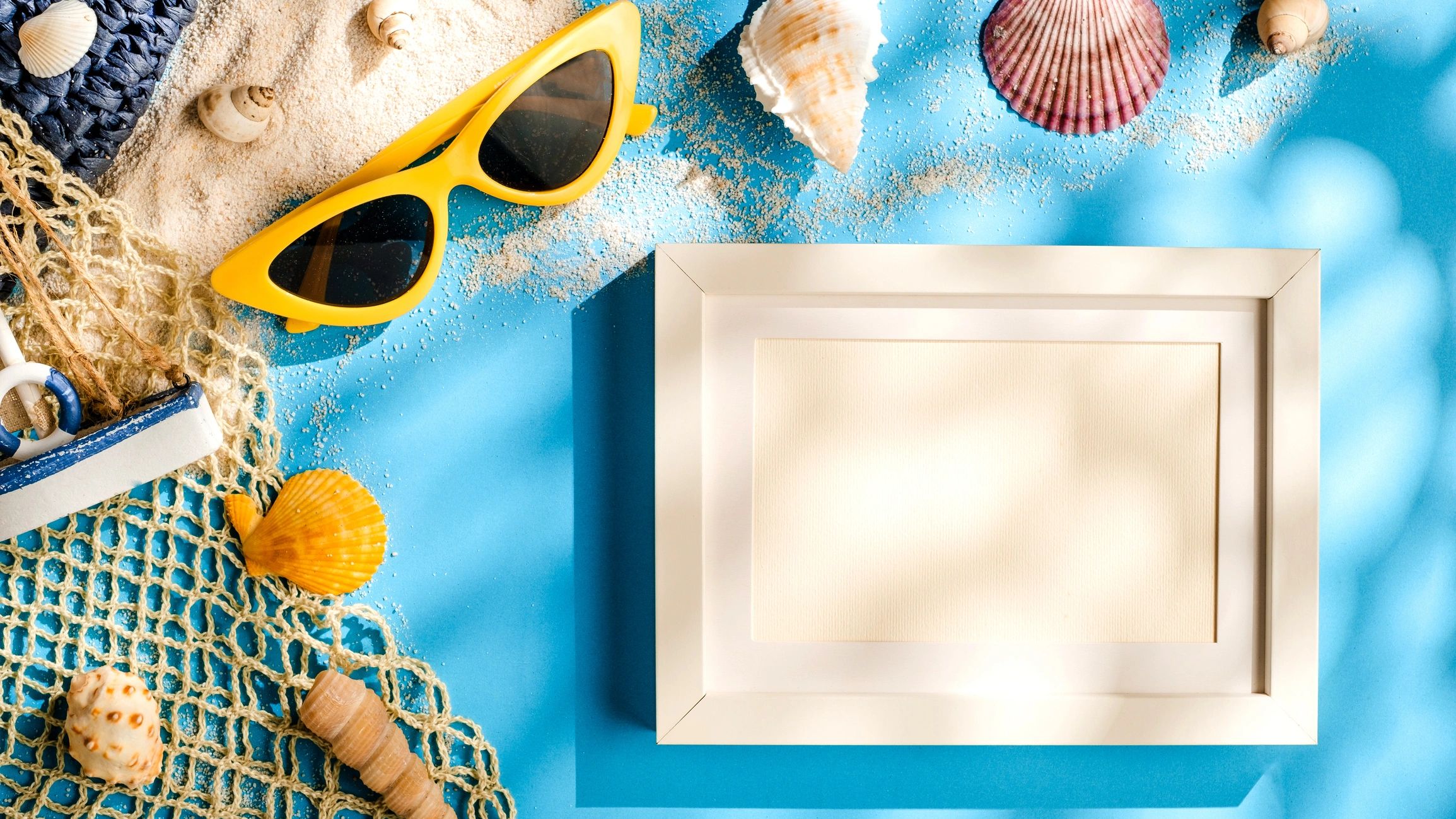 Beach accessories arranged on a blue coastal background